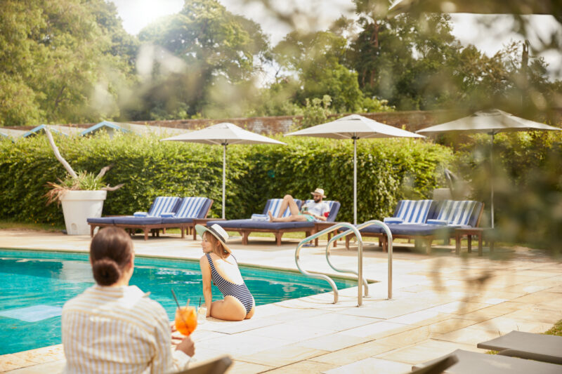 people by the pool in the walled garden at The Grove