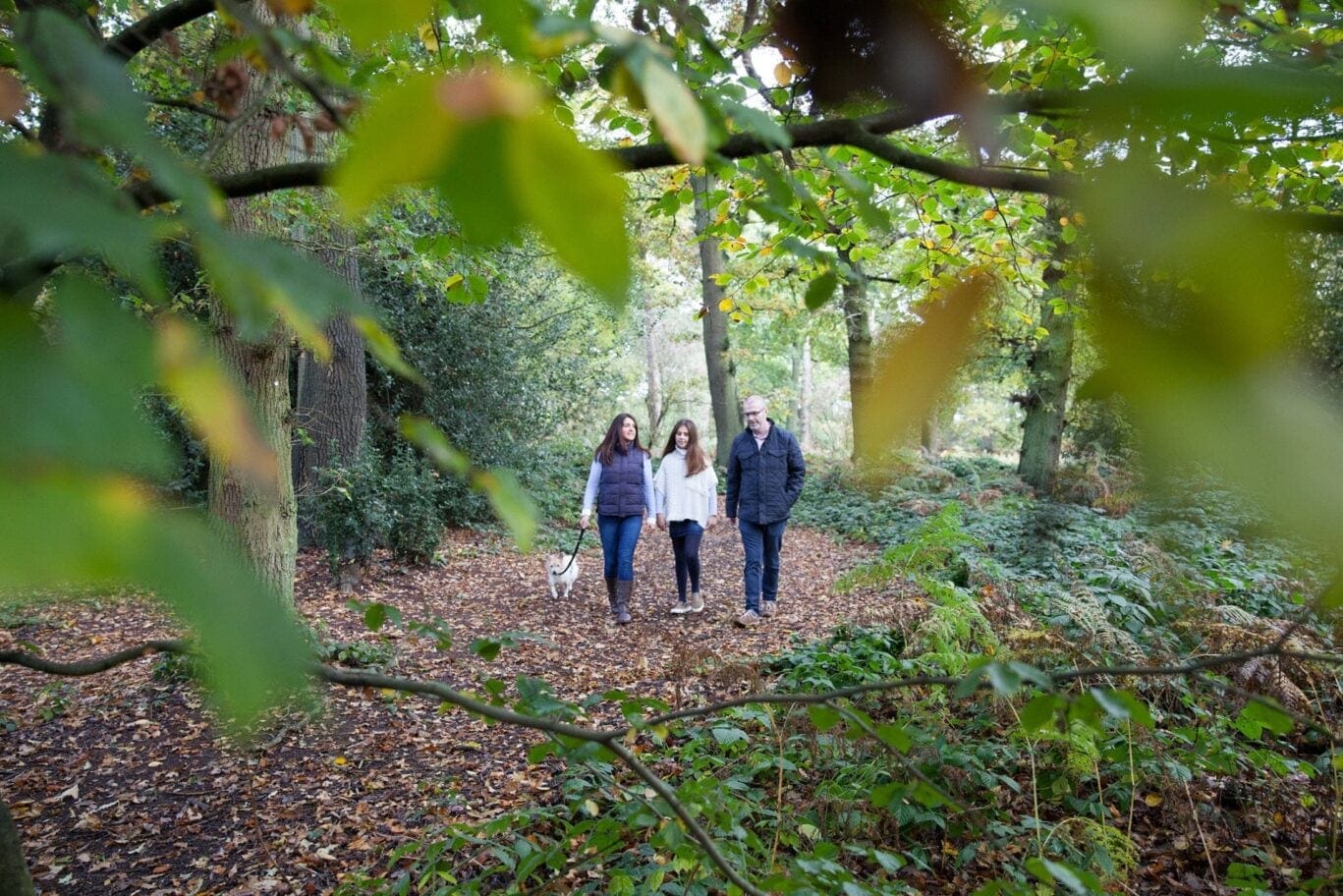 family in the woodland walking a dog