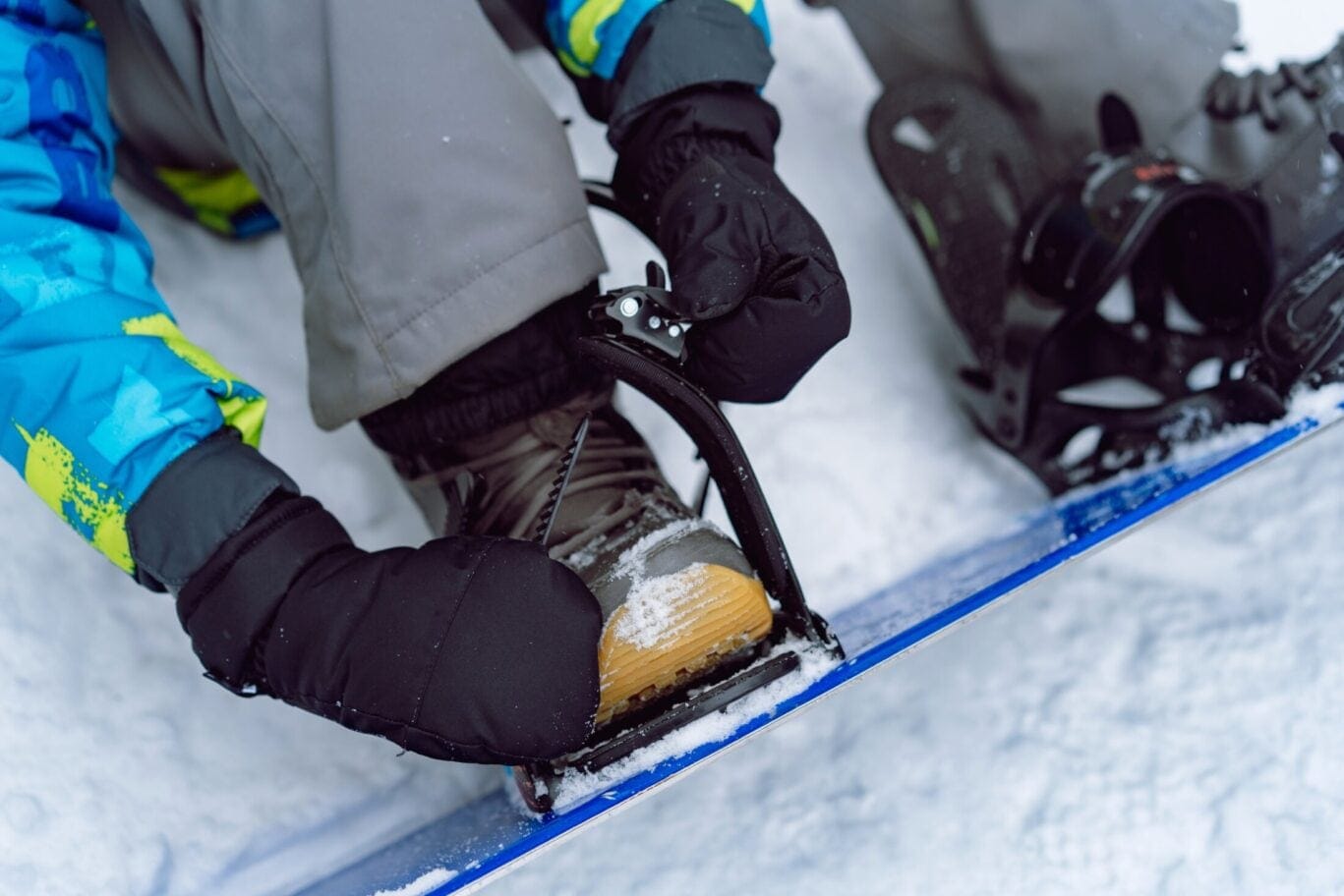Close,Up,Vie,Of,Little,Boy,Sitting,On,Snow,Putting
