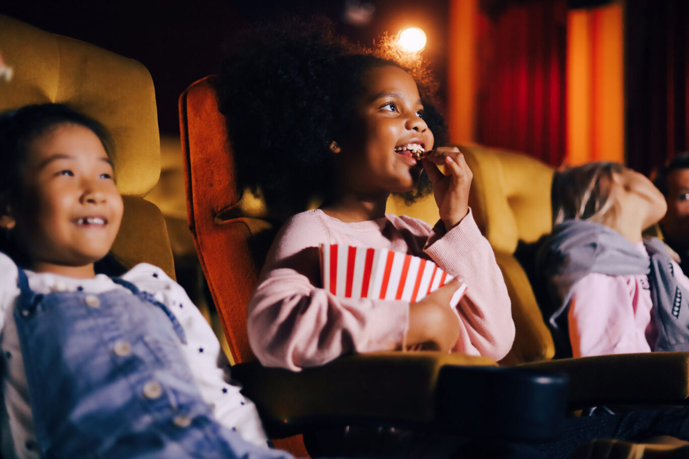 Kids enjoying popcorn and movie at the cinema
