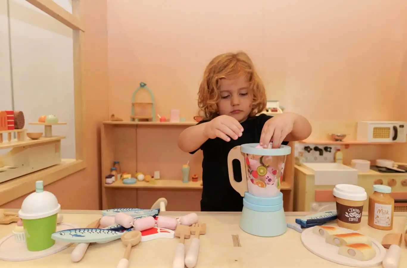 Child playing with toy blender at Pocket Towns café