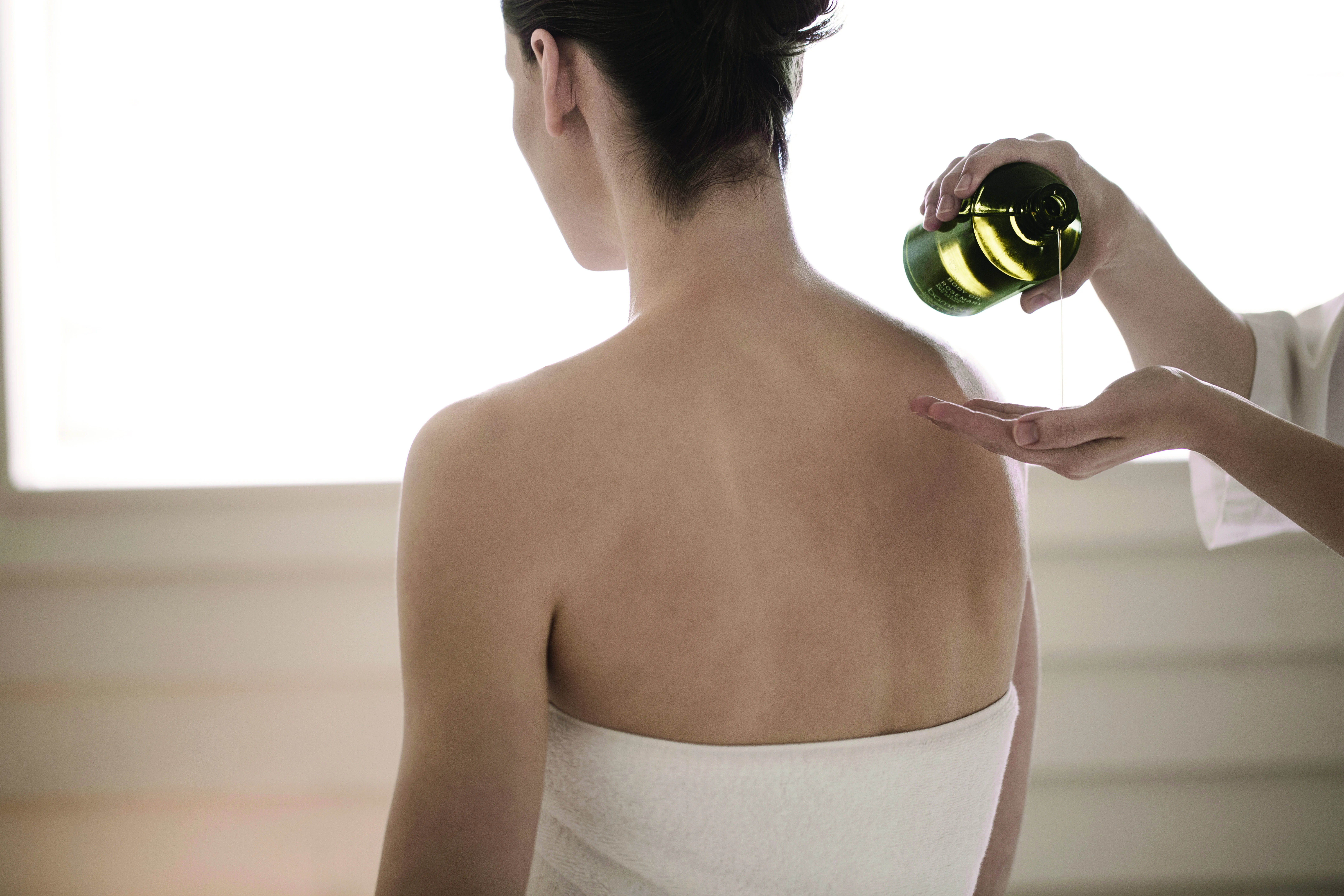 Therapist pouring oil